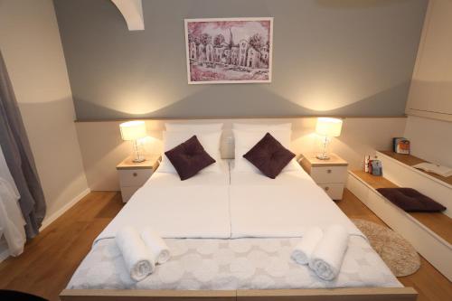 a bedroom with a large white bed with two lamps at Luxury Maraschino Apartments in Zadar