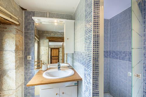 ein Bad mit einem Waschbecken und einem Spiegel in der Unterkunft Superbe appartement, situé au cœur de la ville. in Auch