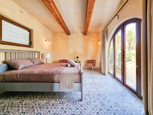 1 dormitorio con cama y ventana grande en Luxury Farmhouse Villa surrounded with Nature & Farm Animals Alpacas etc, en Għasri