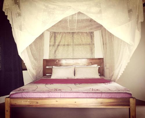 a bedroom with a canopy bed with a window at Playa Paraiso Nagtabon Beach in Bacungan