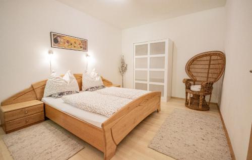 ein Schlafzimmer mit einem Holzbett und einem Stuhl in der Unterkunft Gästehaus Wechselberger in Steinach am Brenner