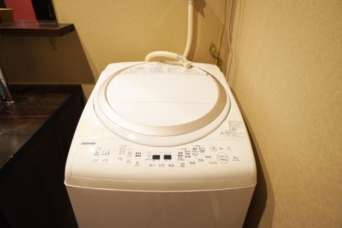 a washing machine sitting in a corner of a room at MUSUBI Sanjo Bettei in Kyoto