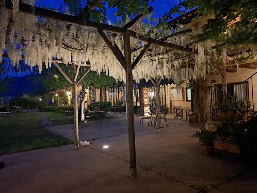 a pergola with white wreaths hanging from it at Cascina La Commenda in Peveragno