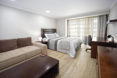 una sala de estar con una cama y un sofá en Coresi rezidence & suites, en Brasov