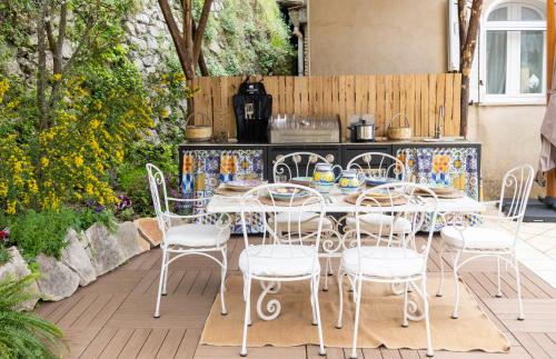 un patio con tavolo e sedie e una cucina di Casa Romelide Positano Amazing view, free parking along the street, free breakfast basket a Positano