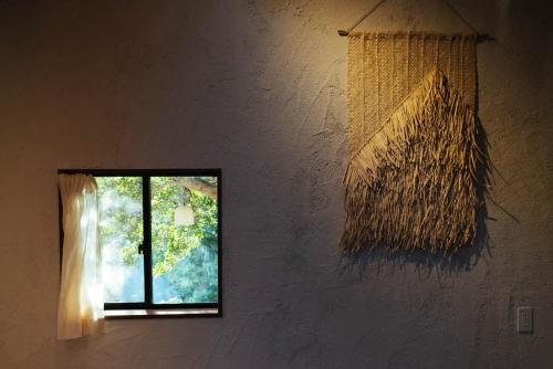 a window in a white wall with a window curtain at Villa Yumigahama in Minamiizu