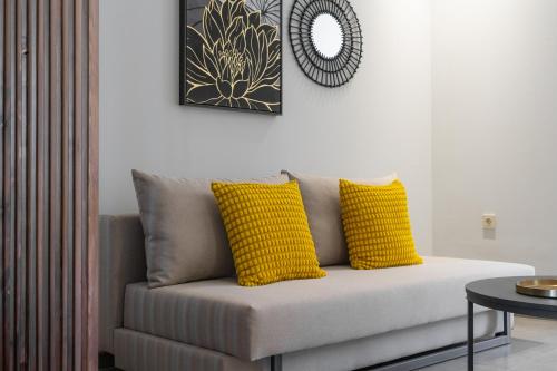 a couch with two yellow pillows in a living room at Meliora Suites in Drapaniás