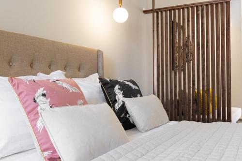 a bedroom with a bed with white sheets and pillows at Meliora Suites in Drapaniás