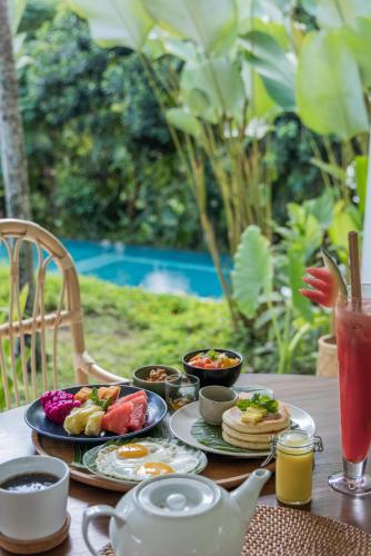 The White Villas Ubud في أوبود: طاولة عليها أطباق طعام وشراب