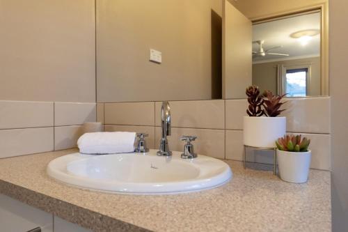 La salle de bains est pourvue d'un lavabo blanc et d'un miroir. dans l'établissement Bella Nicola, à Bright