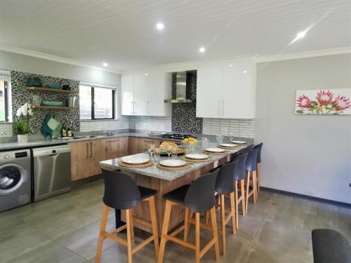a kitchen with a large wooden table and chairs at The Bird Hide Luxury Self catering in White River