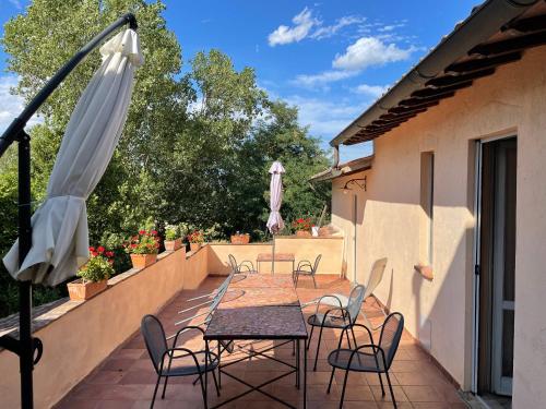 a patio with a table and chairs and an umbrella at La Fratta Art - House in Marsciano