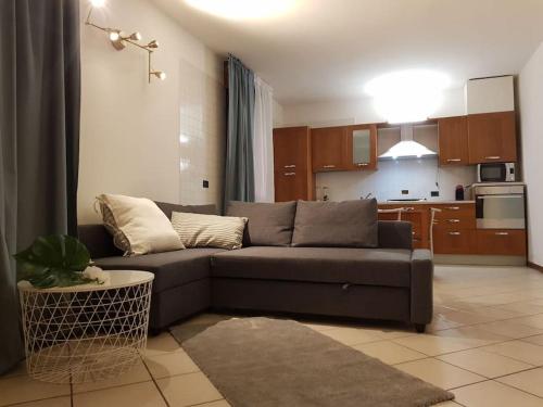 a living room with a couch and a kitchen at Cozy Home in Sommacampagna