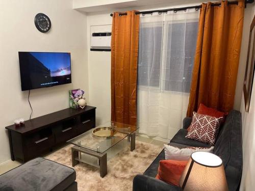 a living room with a couch and a tv at The Journeyman Suite at Covent Garden Sta Mesa Manila in Manila