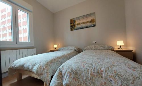 2 letti in una camera da letto con 2 lampade e una finestra di Preciosa Habitación a 10 min del centro de Bilbao H2 a Bilbao
