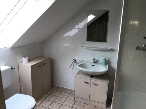 ein Bad mit einem Waschbecken und einem WC in der Unterkunft (2) Spiekeroog in Dornum