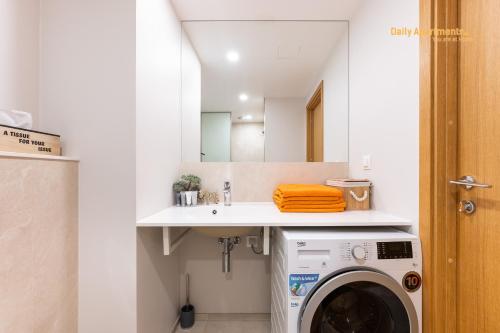 a bathroom with a washing machine and a sink at Luxury Suites - Rotermann by Rikas Hotels in Tallinn