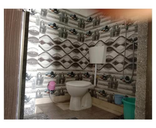 a bathroom with a toilet and a wall of shoes at Hotel Prem Vilas Paradise By WB Inn in Pātolī