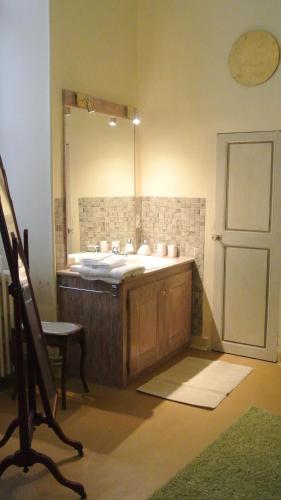 une salle de bain avec un lavabo et un grand miroir dans l'établissement Maison d'hôtes - Hôtel particulier de Jerphanion Cambacérès, au Puy-en-Velay
