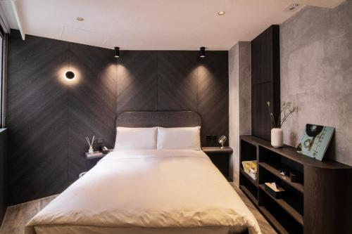 a bedroom with a large bed with a black wall at Hillwood House Hotel in Hong Kong
