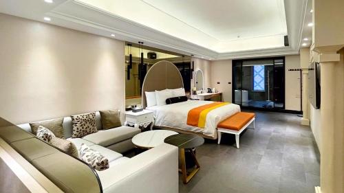 um quarto de hotel com uma cama e um sofá em H Motel璽悅國際精品旅館 em Zhubei