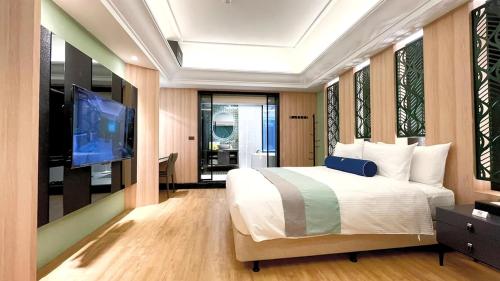 a bedroom with a large bed and a flat screen tv at H Motel璽悅國際精品旅館 in Zhubei