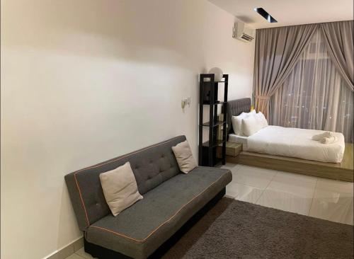 een woonkamer met een bank en een bed bij Studio with a Balcony @Twin Galaxy Residence in Johor Bahru