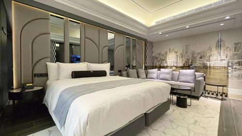 a bedroom with a large bed and a couch at H Motel璽悅國際精品旅館 in Zhubei