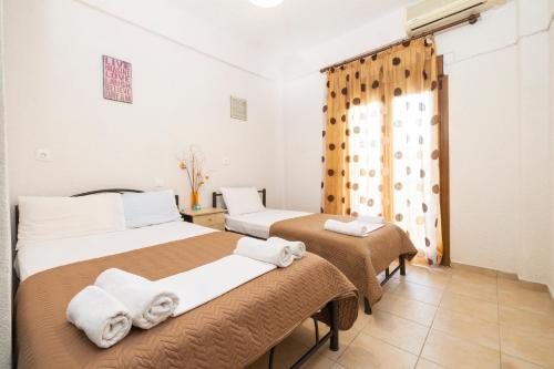 a hotel room with two beds and a window at Alexandra Studios in Kallithea Halkidikis