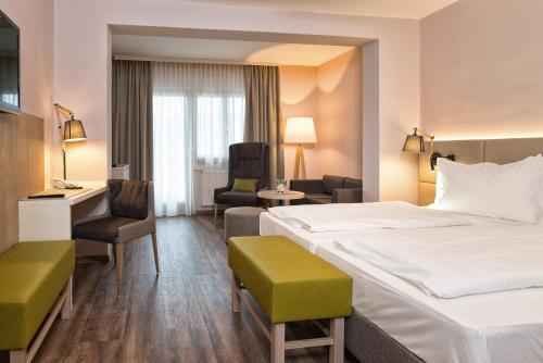 Pokój hotelowy z 2 łóżkami i biurkiem w obiekcie Simon - das Vitalhotel w mieście Bad Tatzmannsdorf