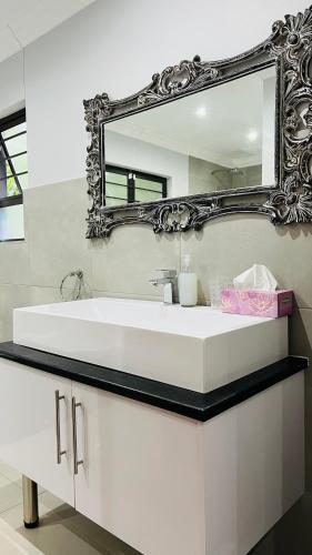 a bathroom with a white sink and a mirror at Robyns Nest Self Catering Flat No3 in Kloof
