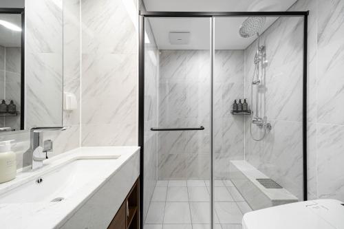 a bathroom with a shower and a toilet and a sink at Le Collective Gangnam SAC Signity in Seoul