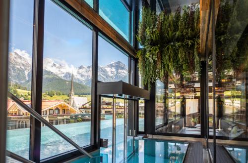 una finestra con vista sulle montagne da un edificio di Hotel Lohningerhof a Maria Alm am Steinernen Meer