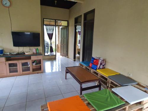 a living room with a table and a tv at Aubrey Villa Ciwidey in Pengalongan