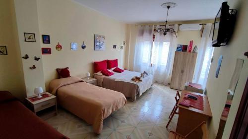 a bedroom with two beds and a television in it at Casa Holiday Sea Etna Di Enza in Linguaglossa