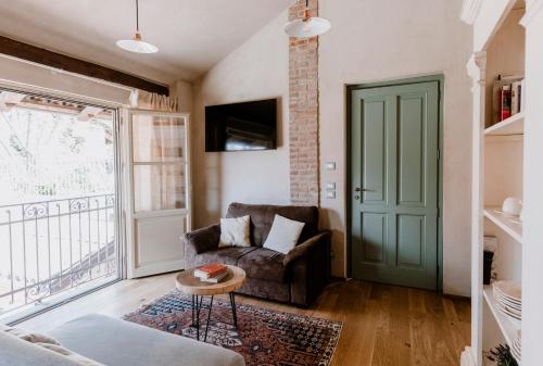 a living room with a couch and a green door at Roero House in Magliano Alfieri