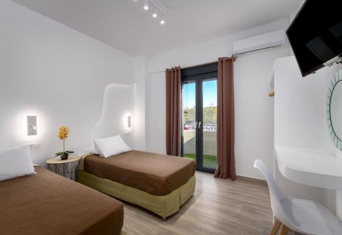 a hotel room with two beds and a window at Christianna & George Luxury Hot Tub Apartment in Fira