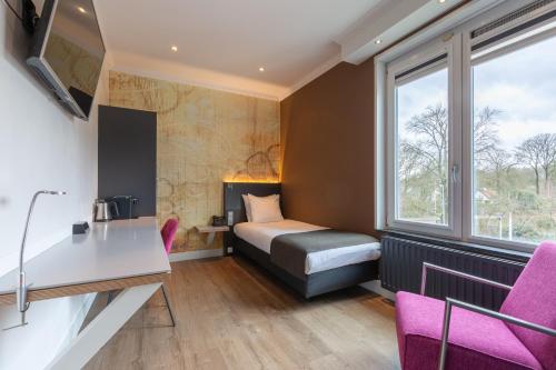 a small room with a bed and a window at Amrâth Berghotel Amersfoort, BW Signature Collection in Amersfoort