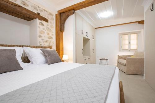 a bedroom with a large white bed and a couch at Angestrale Traditional Residence in Lefkada Town