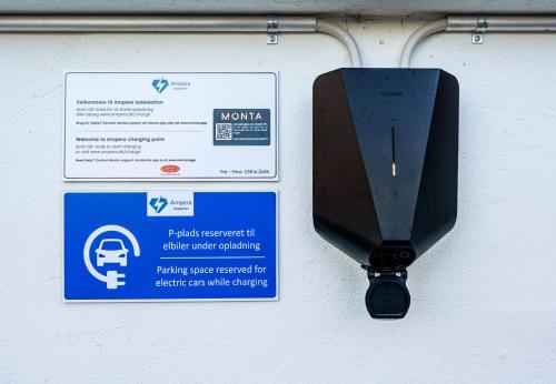 een parkeermeter naast een bord op een muur bij Hotel Phønix Brønderslev in Brønderslev