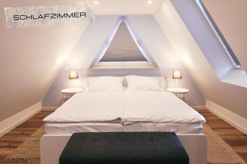 1 dormitorio con 1 cama blanca y 2 mesas en Ferienwohnung Maisonette in ruhiger und zentraler Lage mit Parkplatz, en Büsum