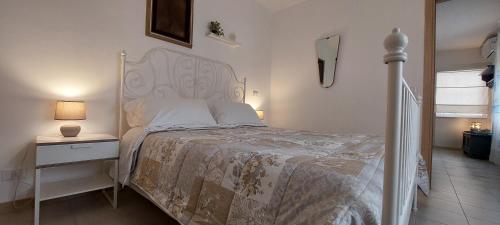 a bedroom with a bed with a white bedspread and a night stand at Dimora Carucci in Noci