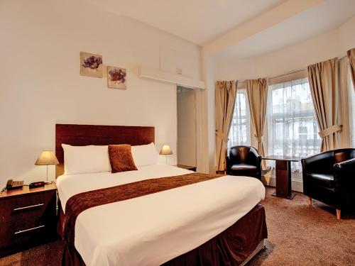 Habitación de hotel con cama grande y escritorio. en The Waverley Hotel, en Great Yarmouth