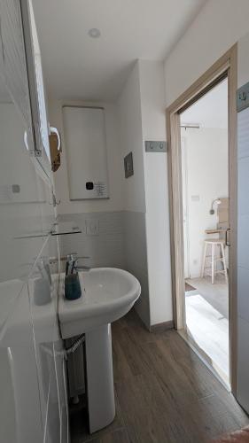 une salle de bain blanche avec un lavabo et une douche dans l'établissement Au Pied du Mur, à Orgnac-lʼAven