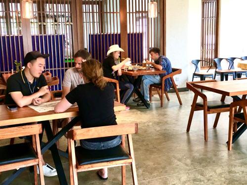 a group of people sitting at tables in a restaurant at Zhangjiajie National Park Nvue Resorts in Zhangjiajie