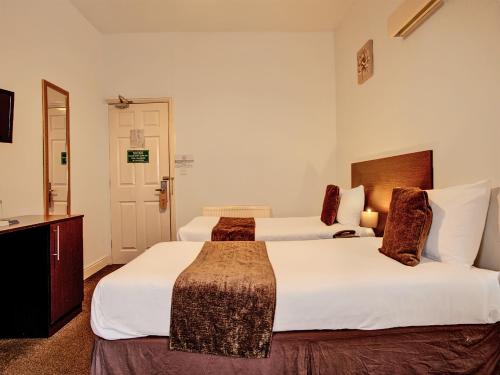 a hotel room with two beds and a television at The Waverley Hotel in Great Yarmouth