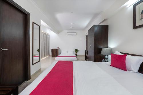 a bedroom with a large white bed with a red rug at Palm Stay - Studios & Rooms in Jaipur
