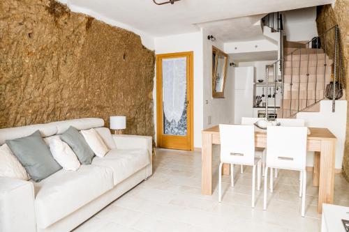 een woonkamer met een witte bank en een tafel bij Sa Rocca in Bosa