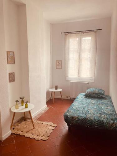 une chambre avec un lit, une table et une fenêtre dans l'établissement Le 122, maison bastide St Louis Carcassonne, à Carcassonne