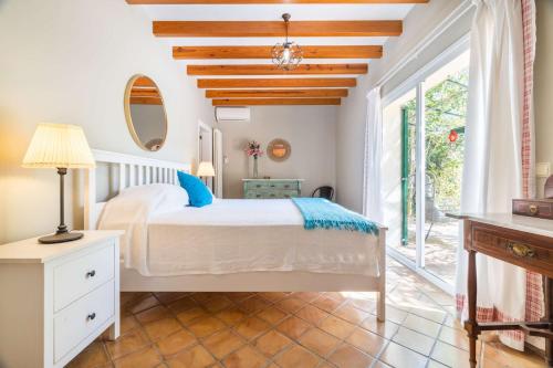 ein Schlafzimmer mit einem Bett und einem großen Fenster in der Unterkunft Finca Santa Maria Near Palma in Santa Maria del Camí